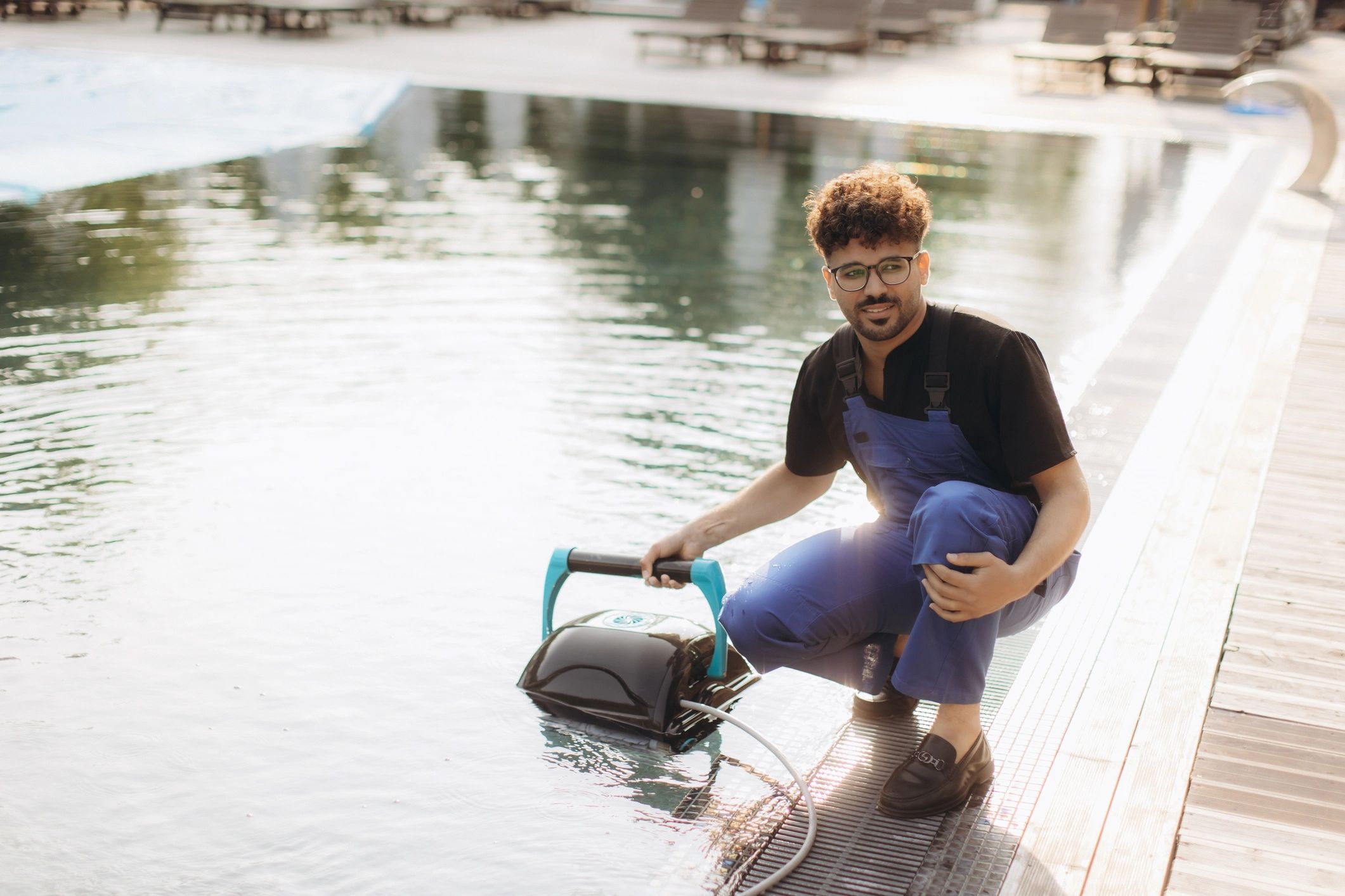 pool cleaner vacuuming and maintaining a backyard swimming pool