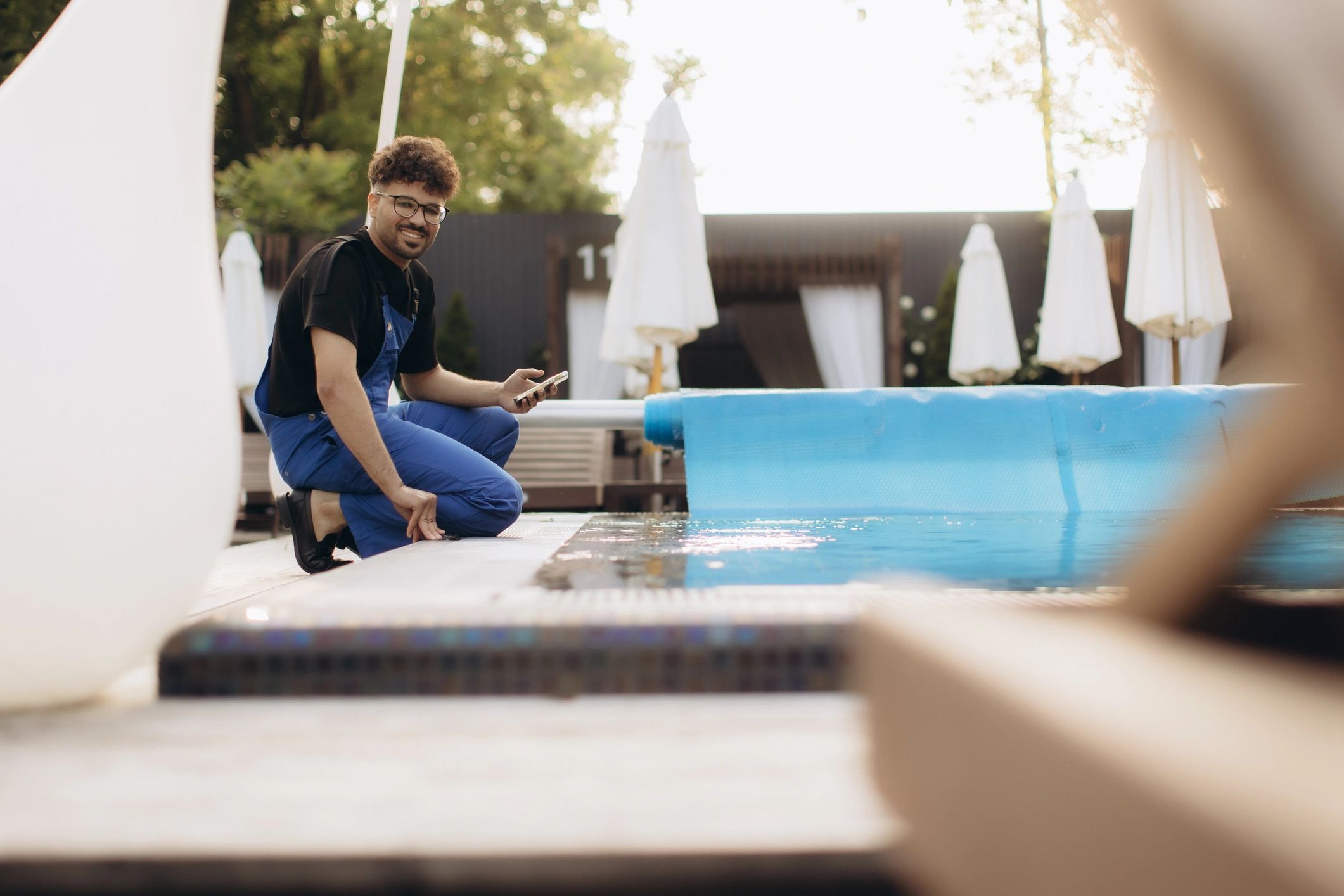 friendly pool technician inspecting pool equipment at a Brisbane home